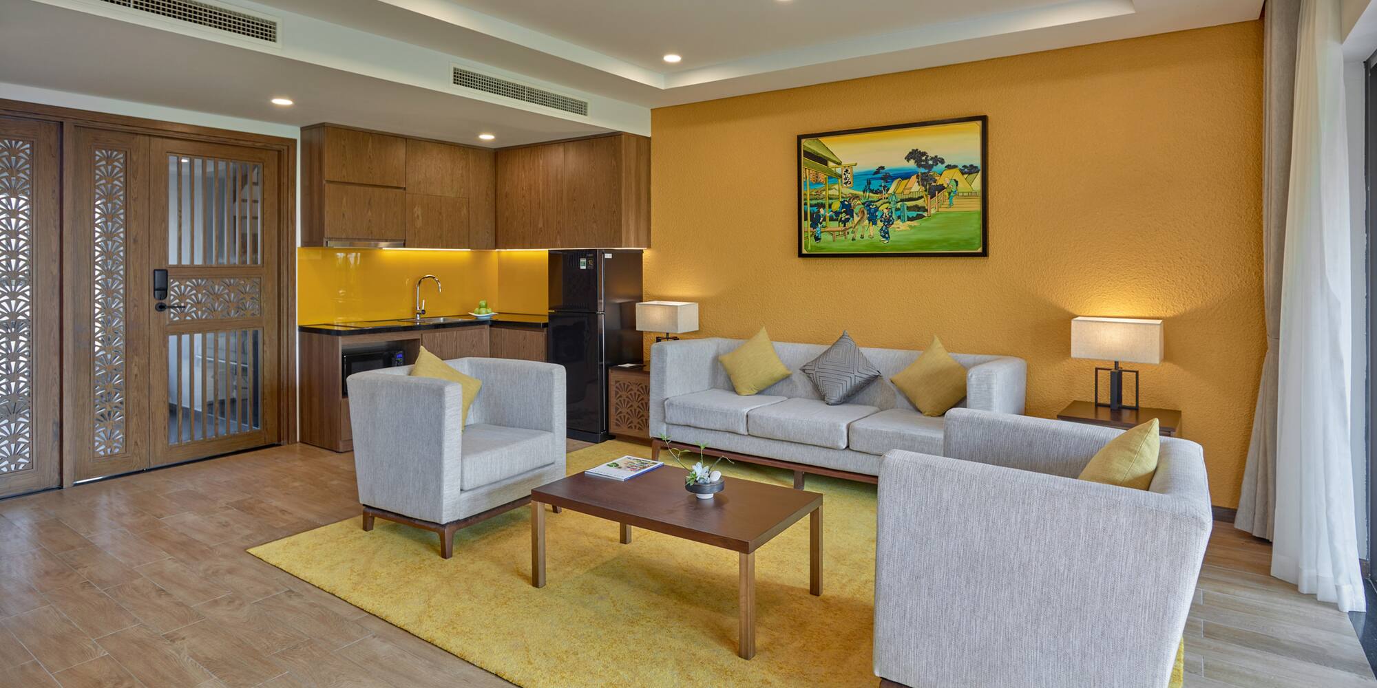 a living room with a yellow wall and white furniture