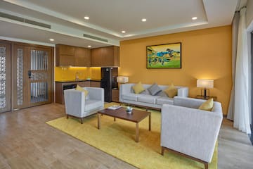 a living room with a yellow wall and white furniture