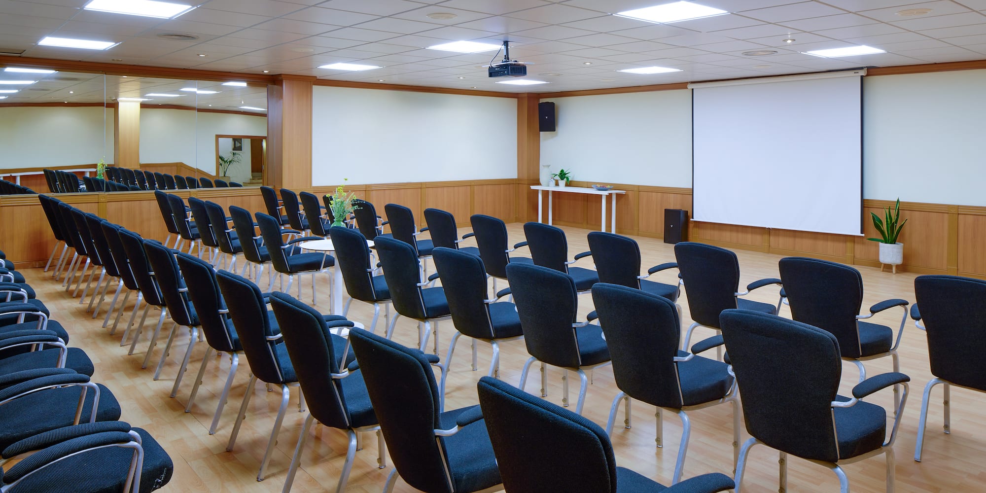 a room with rows of chairs and a projector screen