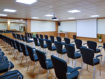 a room with rows of chairs and a projector screen