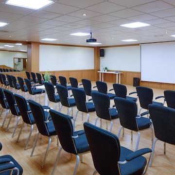 a room with rows of chairs and a projector screen