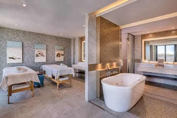 a room with a bathtub and sinks