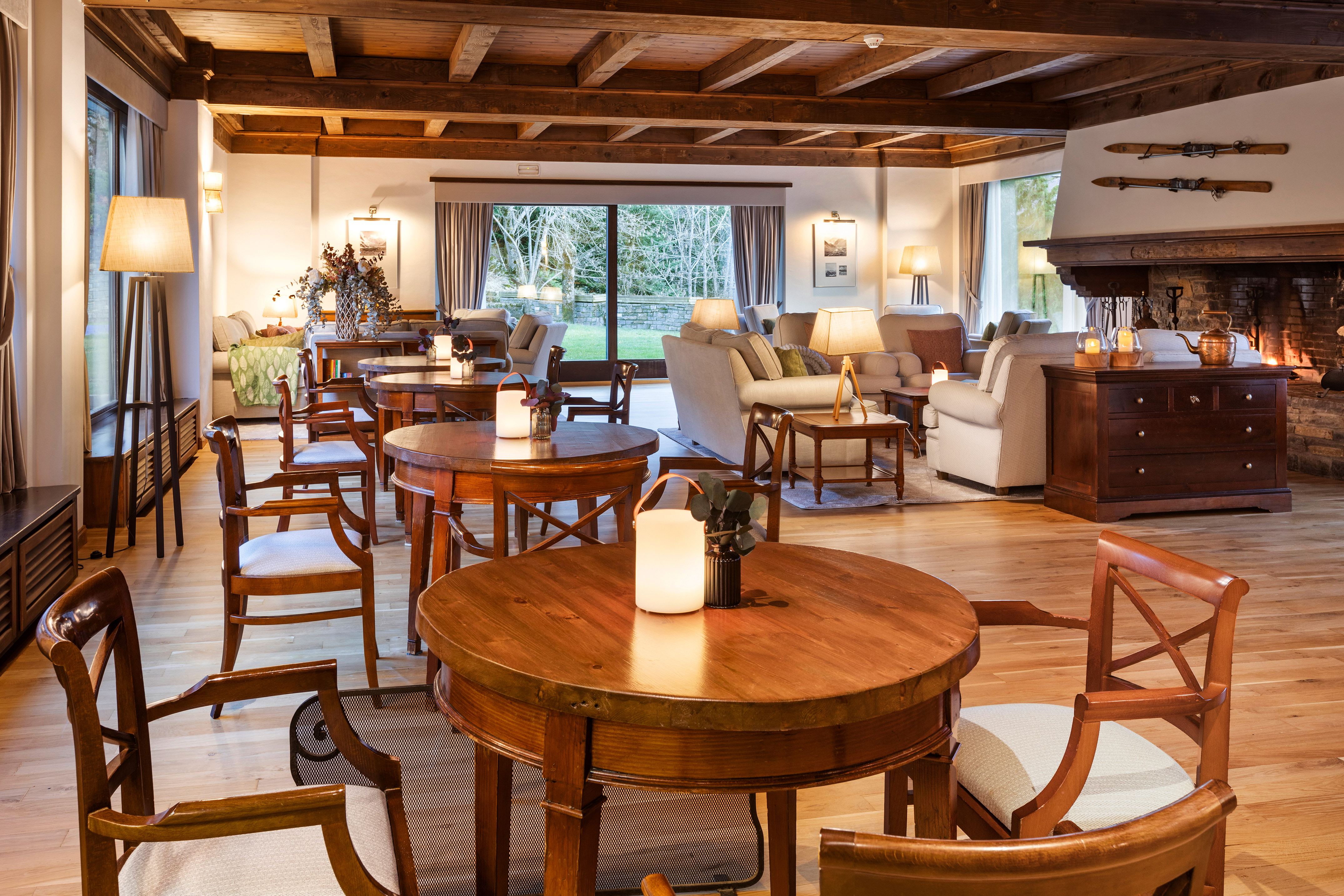Rustic ski lodge lounge with warm fireplace, wooden beams, and comfortable seating.