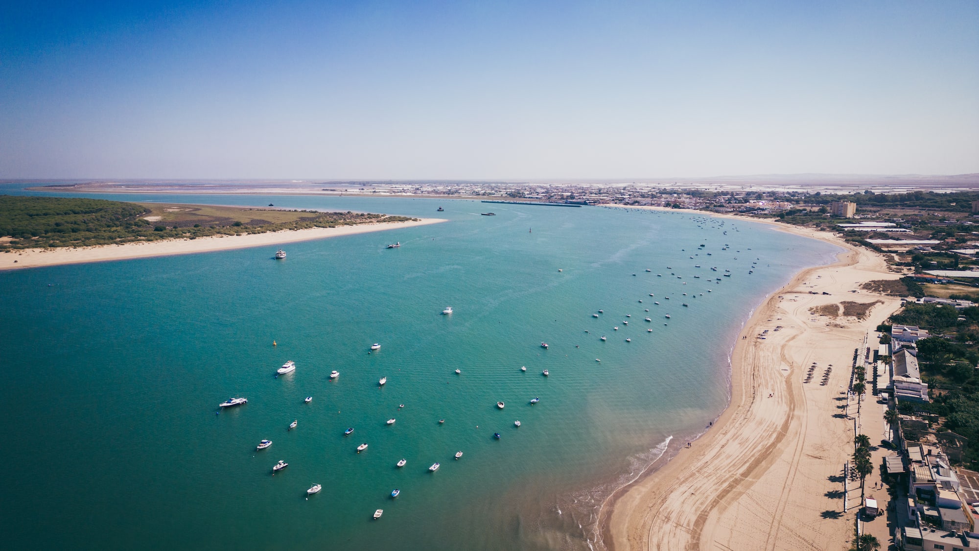 a beach with boats and a body of water