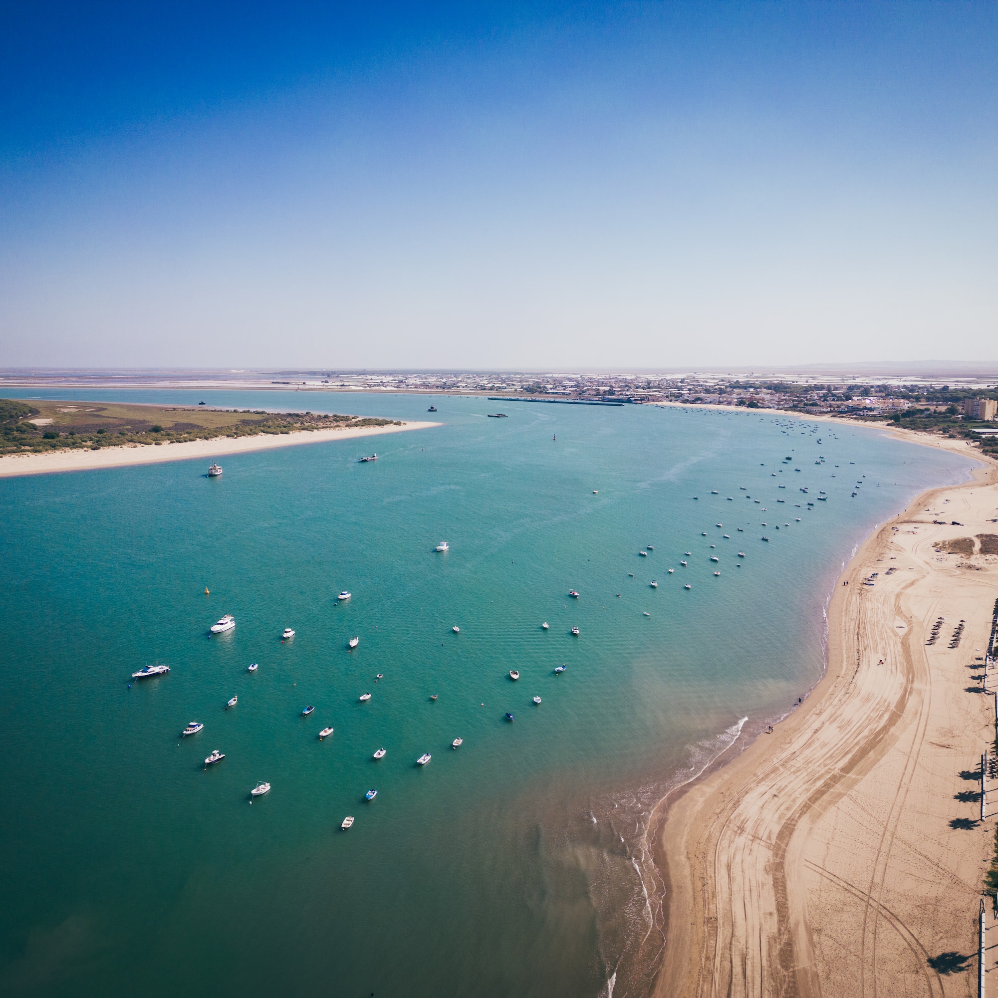 a beach with boats and a body of water