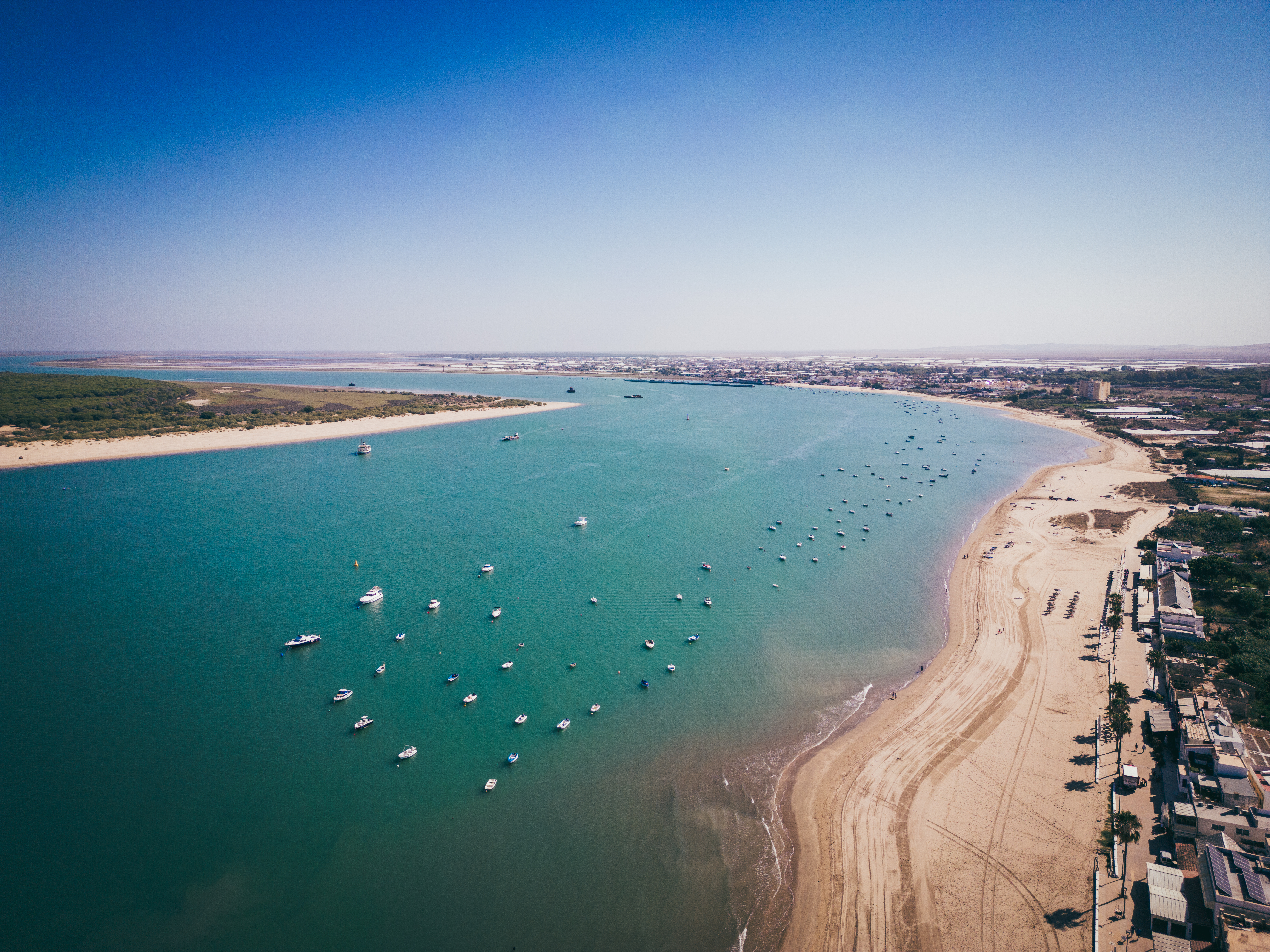 a beach with boats and a body of water