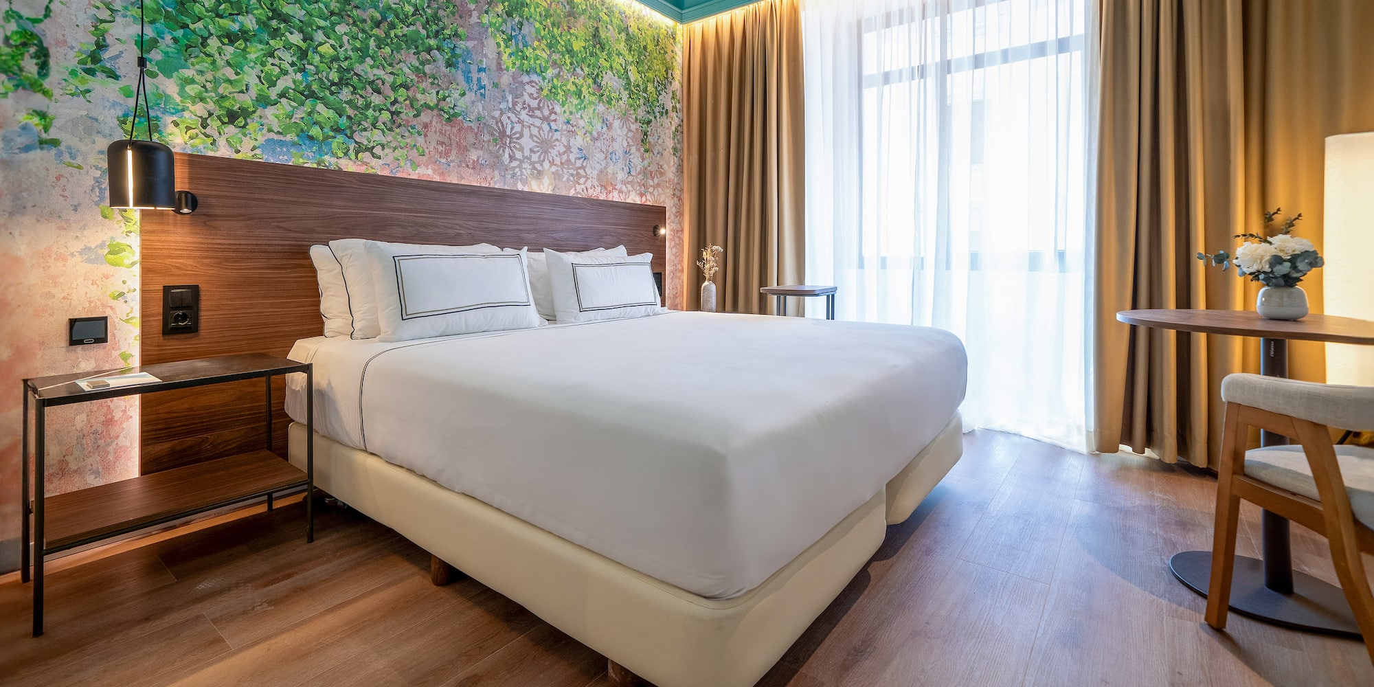 a bed with white sheets and a wood headboard in a room with a window