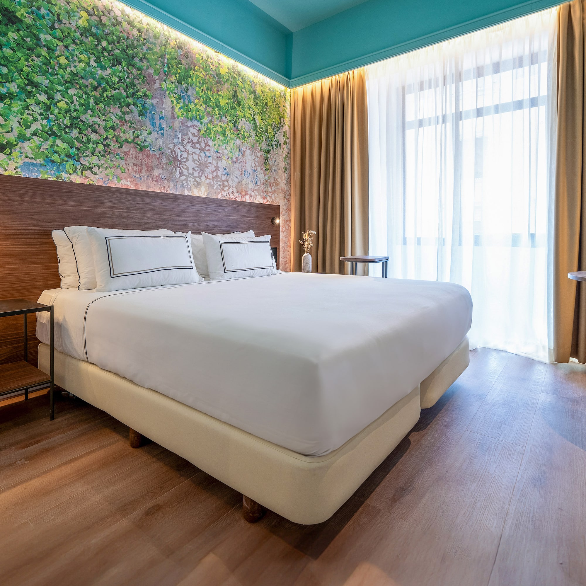 a bed with white sheets and a wood headboard in a room with a window