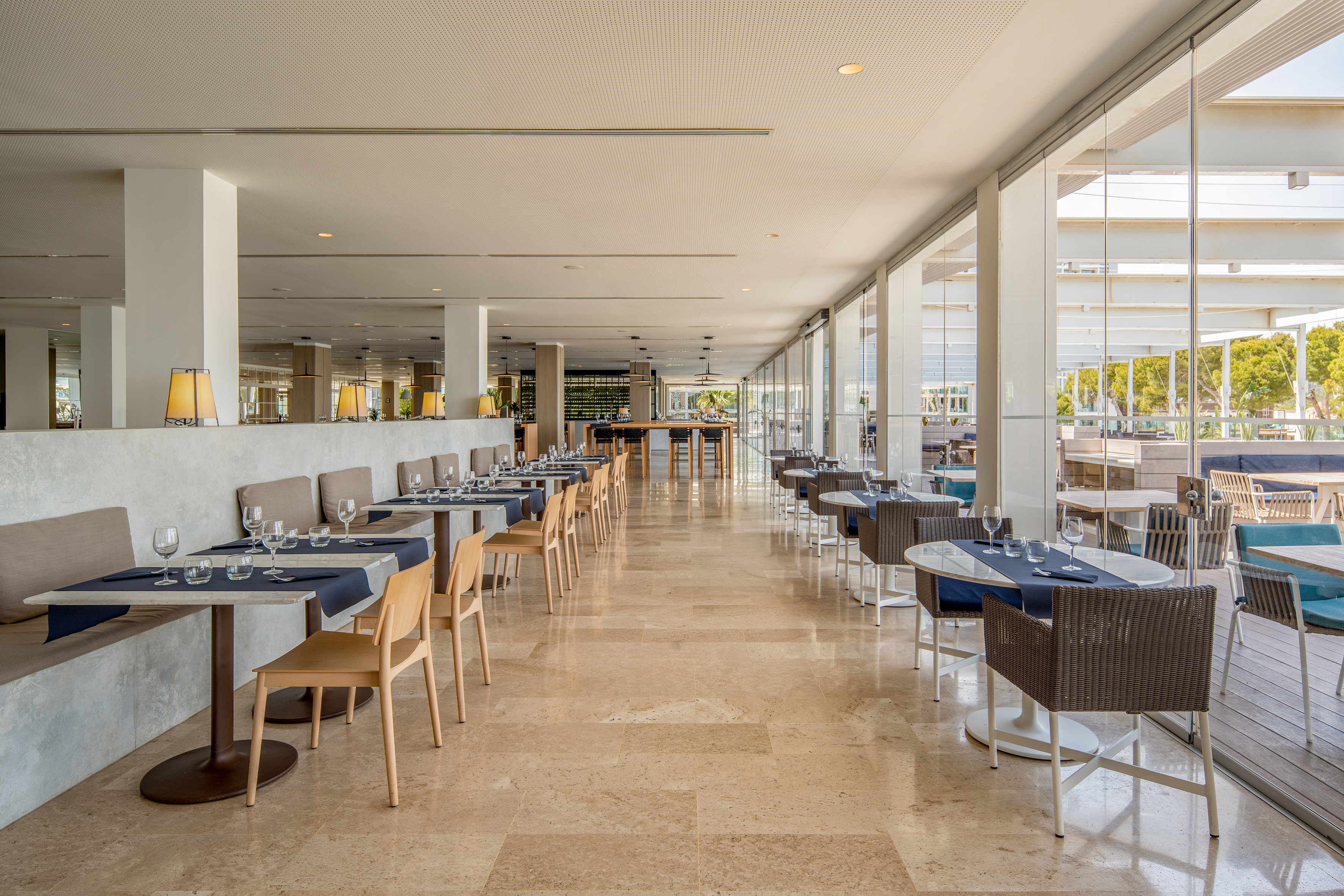 Upscale resort dining room with set tables, polished floors, and large windows.