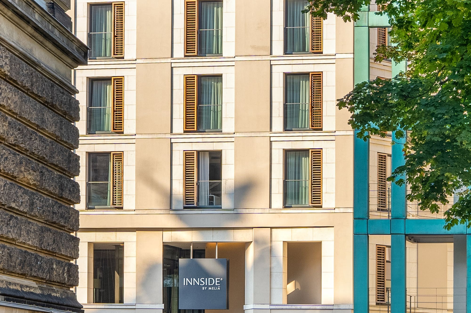 Innside by Meliá hotel building with brown roof and windows on a sunny urban street.