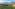 Sunrise over terraced tea fields, bamboo huts, and misty mountains.