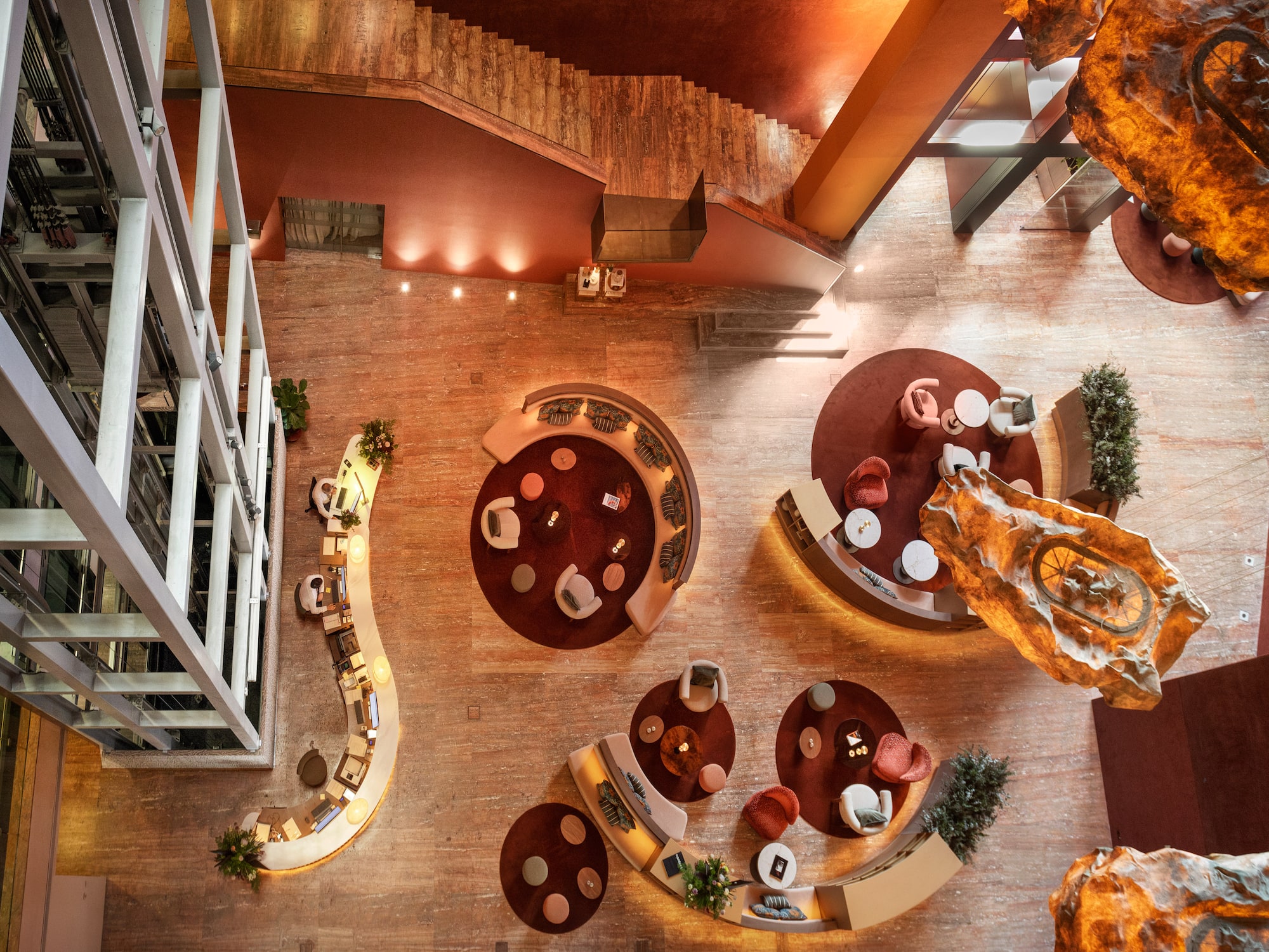 a room with a staircase and tables and chairs