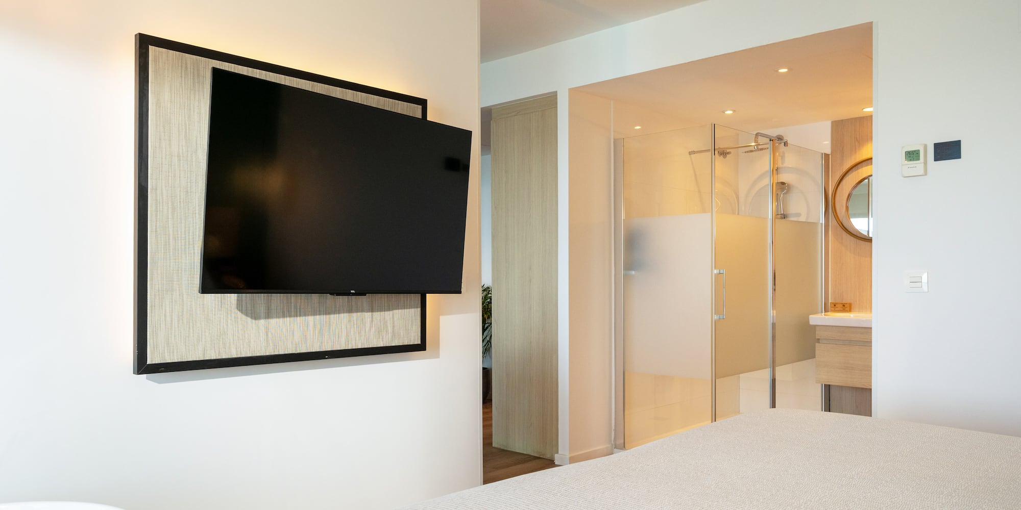 a tv mounted on a wall in a bedroom