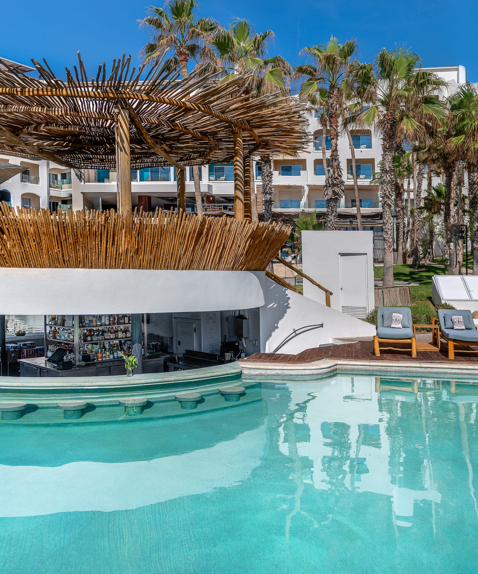 a pool with a bar and lounge chairs