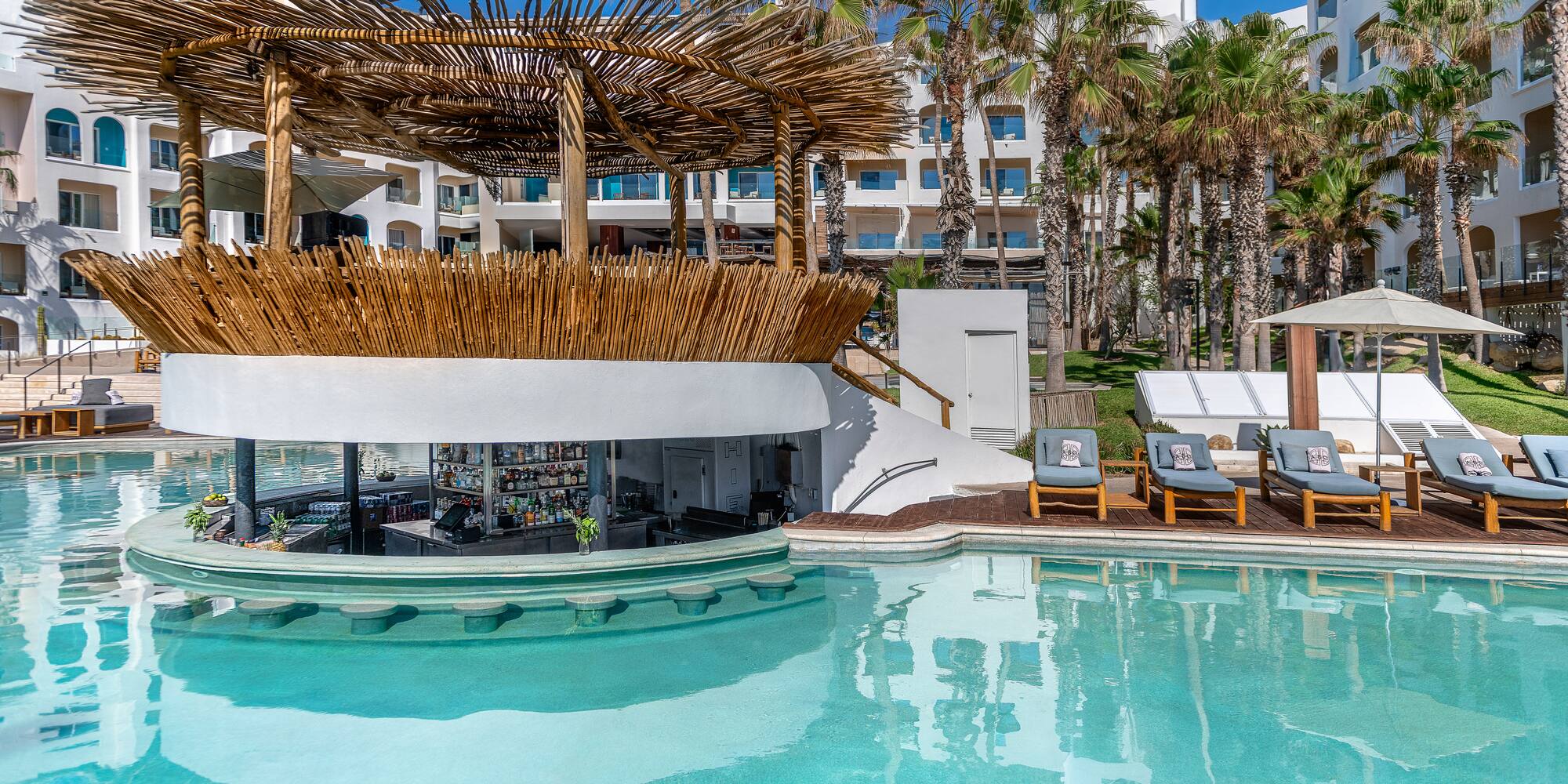 a pool with a bar and lounge chairs