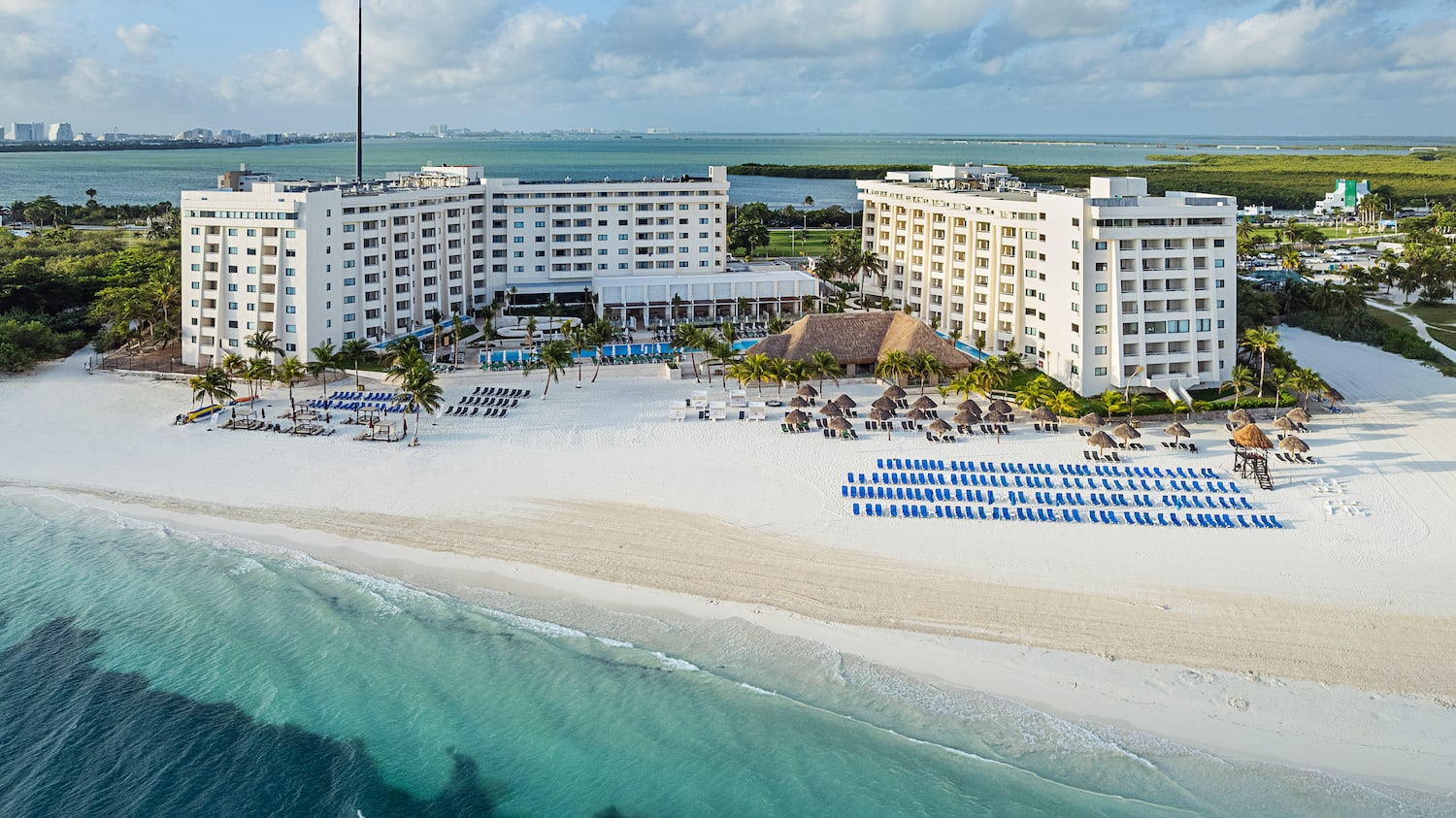a beach with a large building and chairs