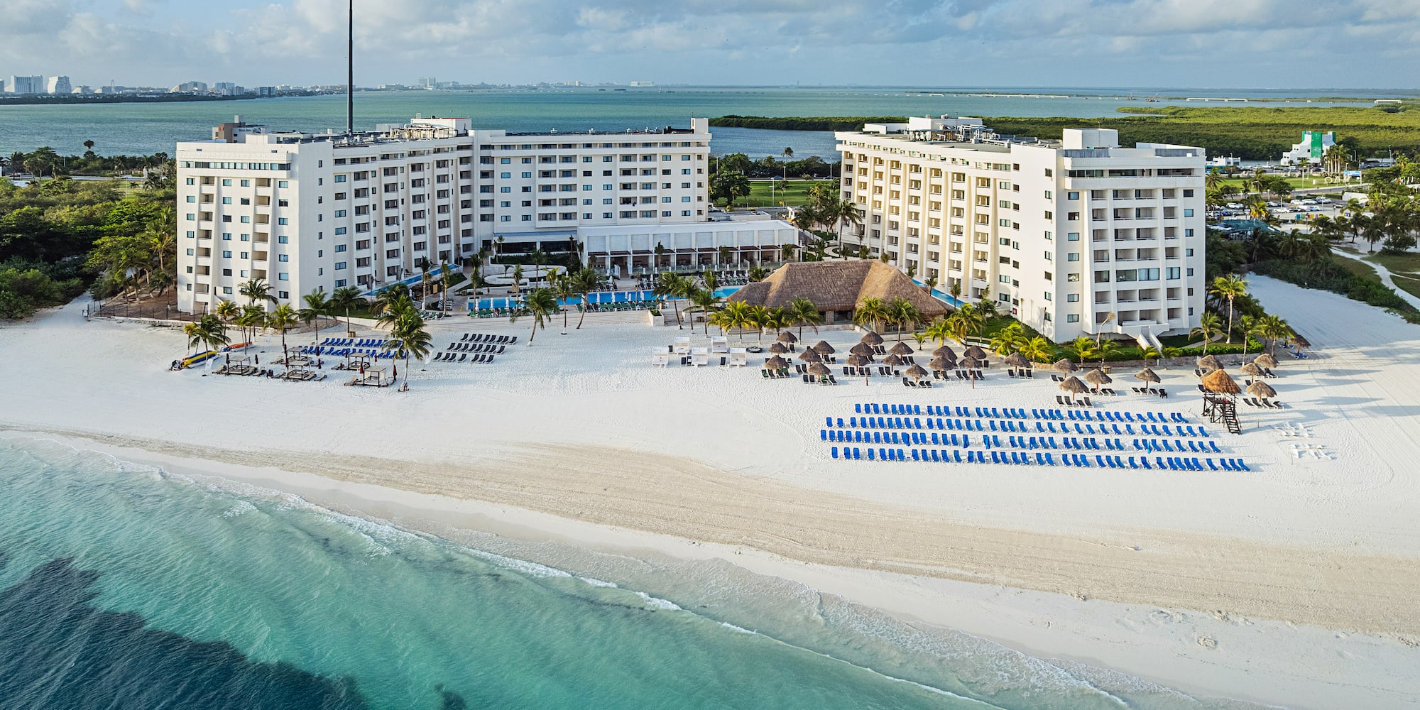 a beach with a large building and chairs