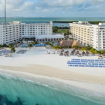 a beach with a large building and chairs