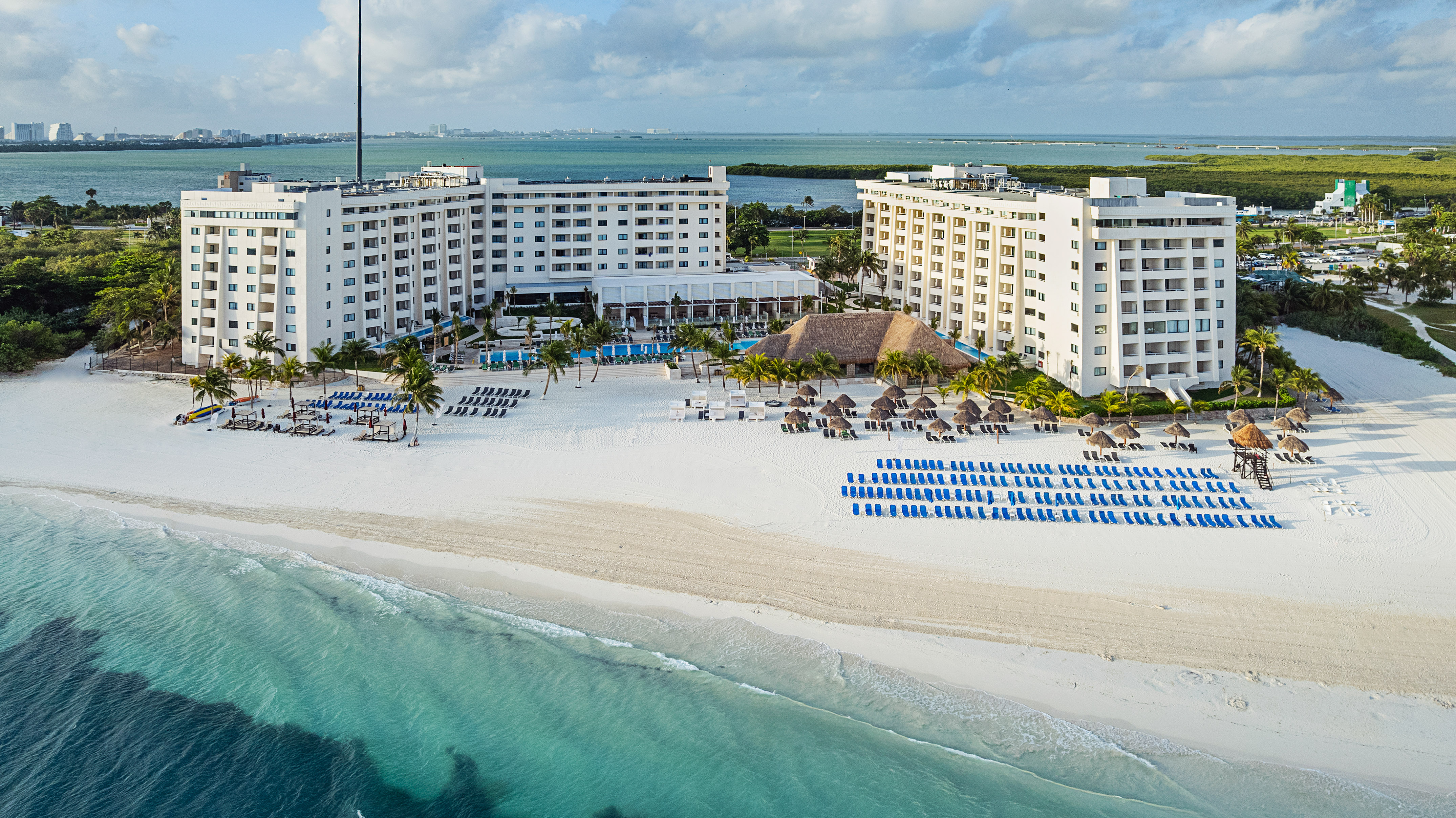 a beach with a large building and chairs