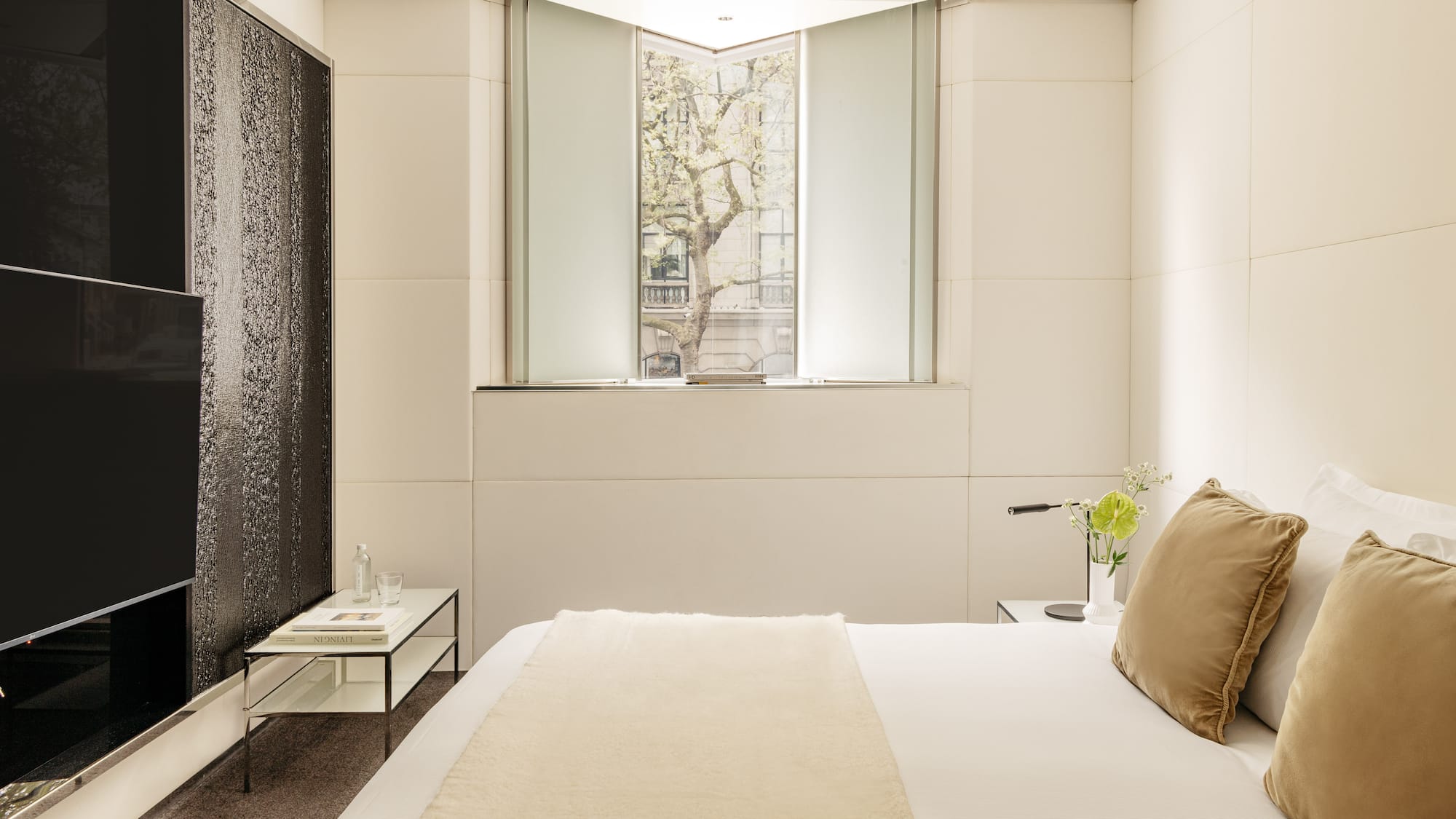 a bed with a pillow and a table with flowers