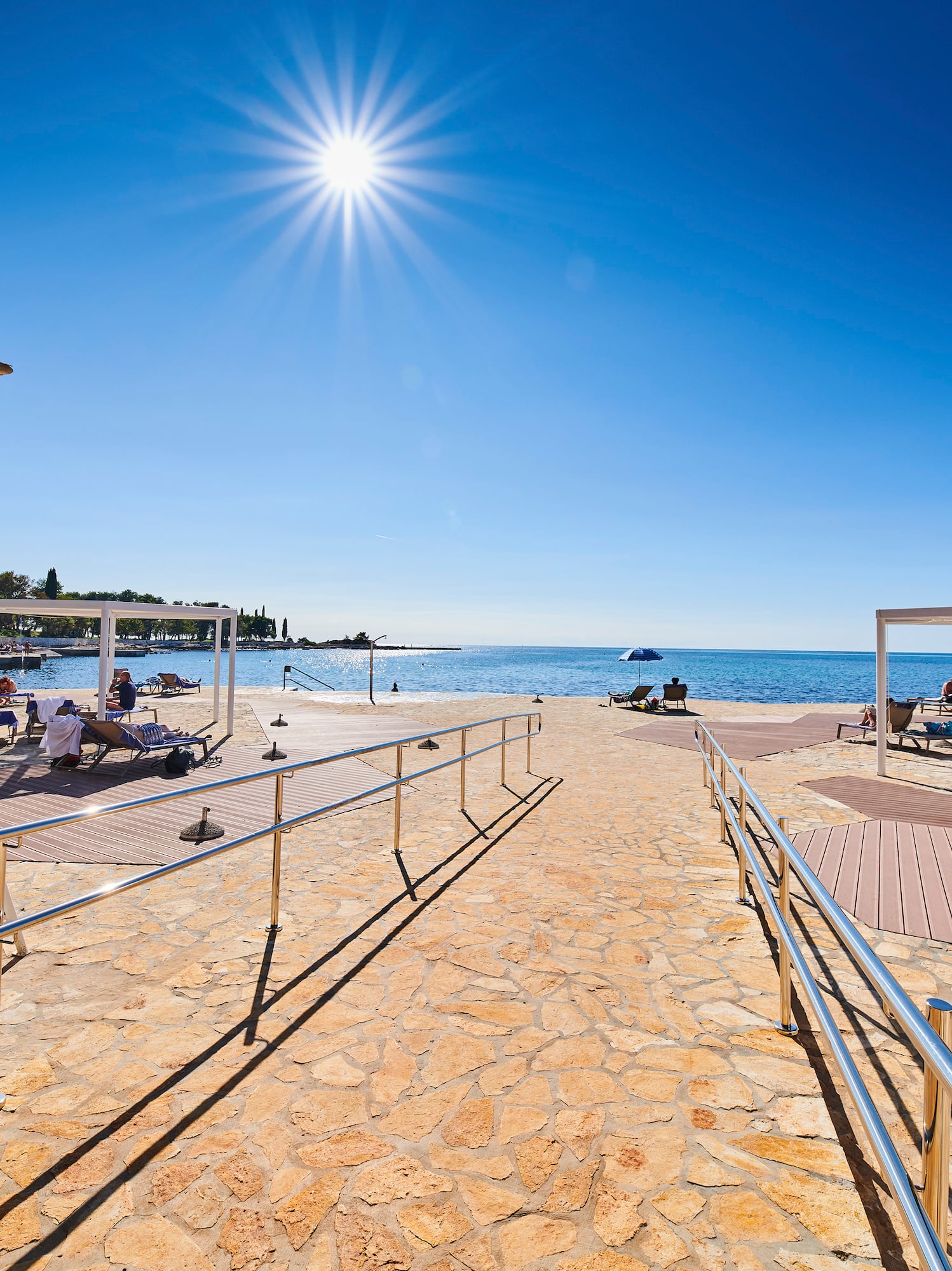 a walkway with a beach and a body of water