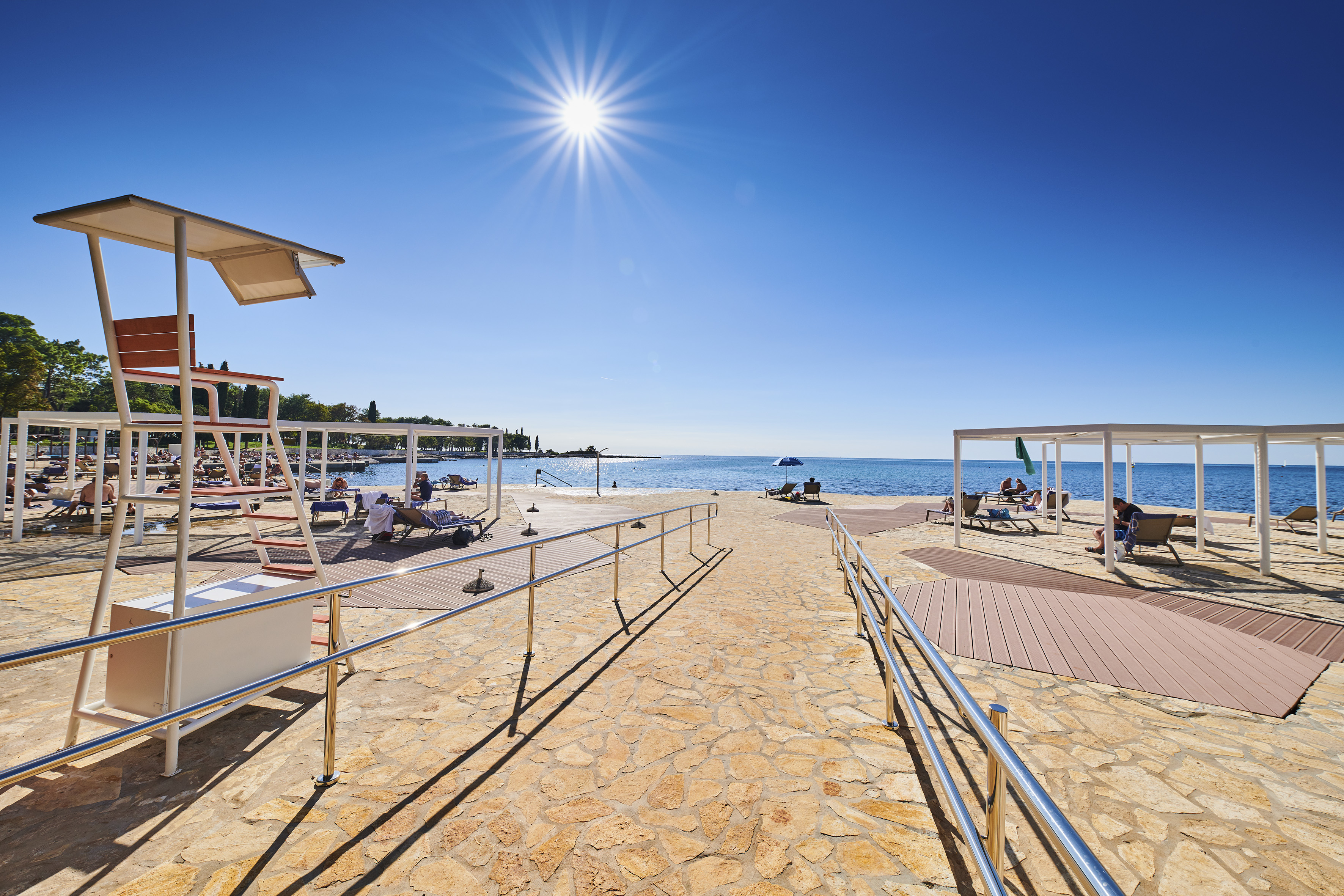 a walkway with a beach and a body of water