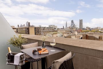 a table with glasses and a book on it with a city in the background