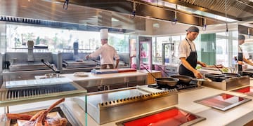 a group of chefs cooking in a kitchen