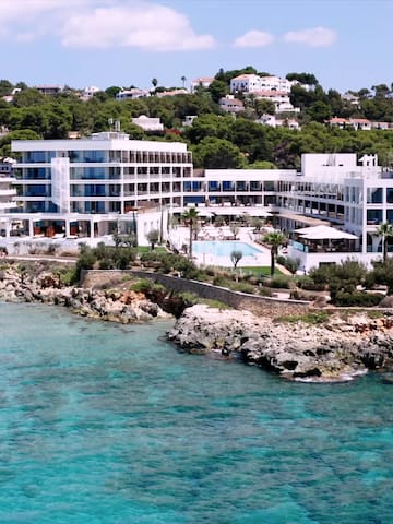 a group of white buildings next to a body of water