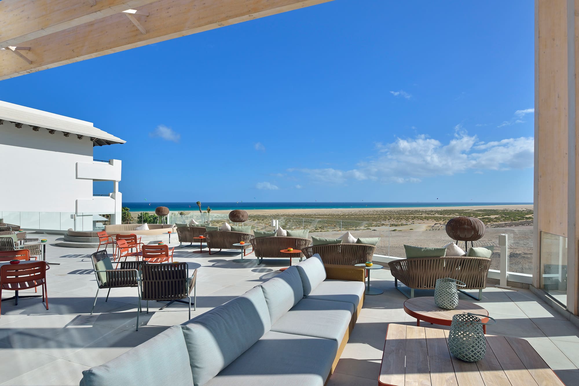 a patio with chairs and tables on a beach