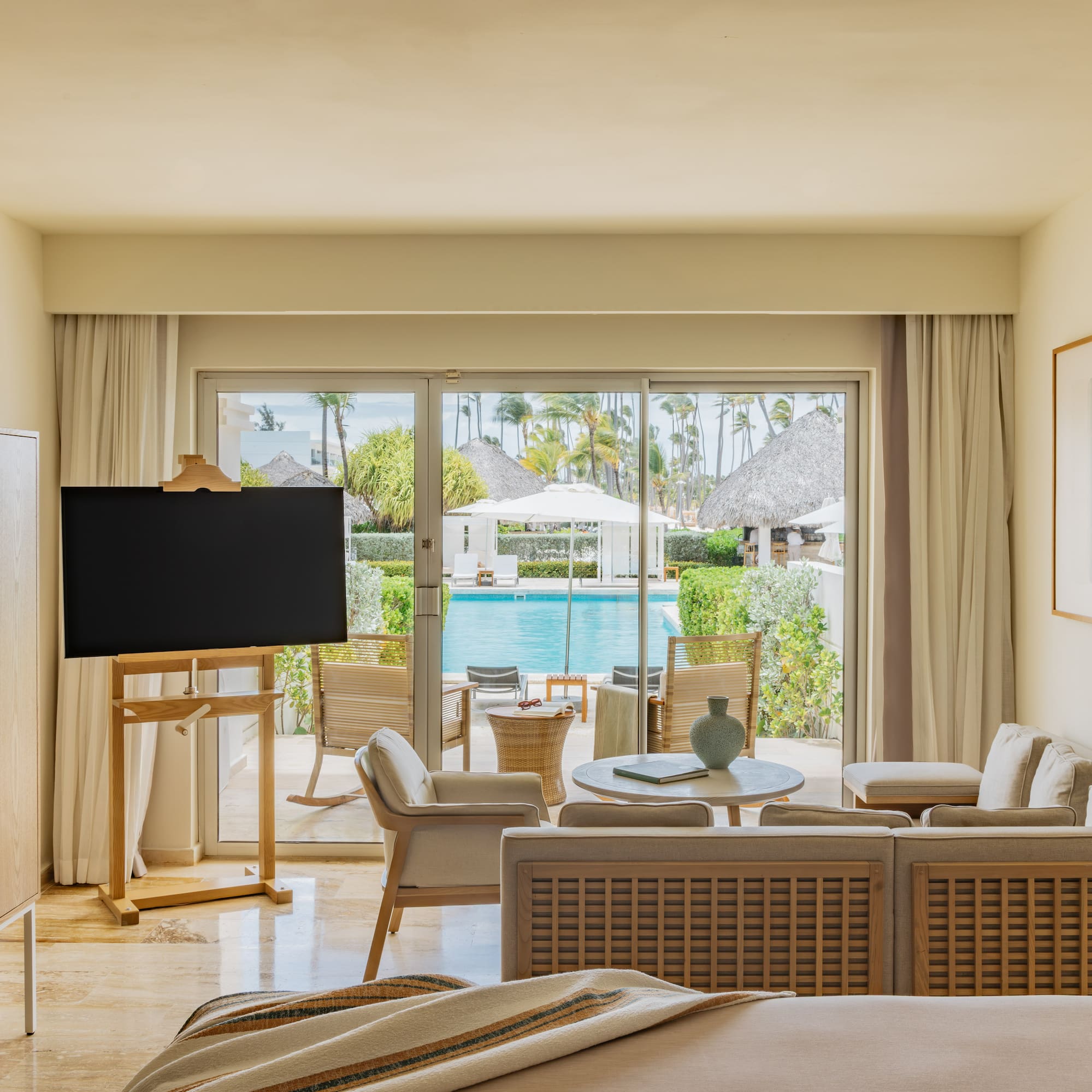 Luxury resort suite with pool view, modern living area, and tropical patio.