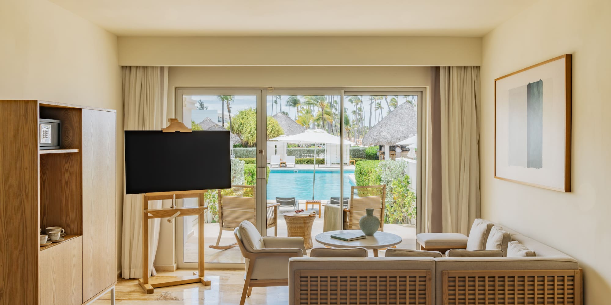 Luxury resort suite with pool view, modern living area, and tropical patio.