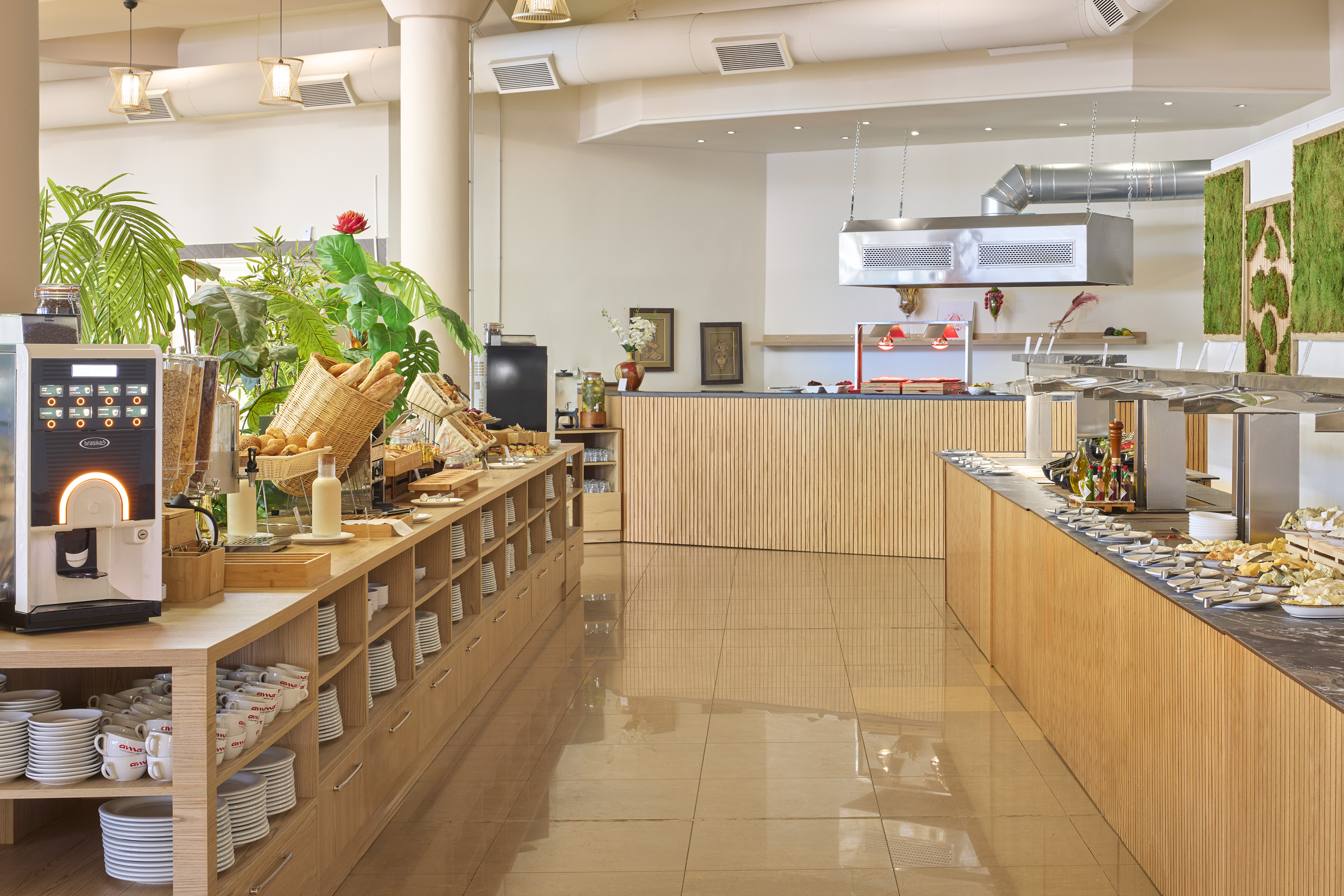 Hotel breakfast buffet with fresh food, coffee machine, and wood paneling.