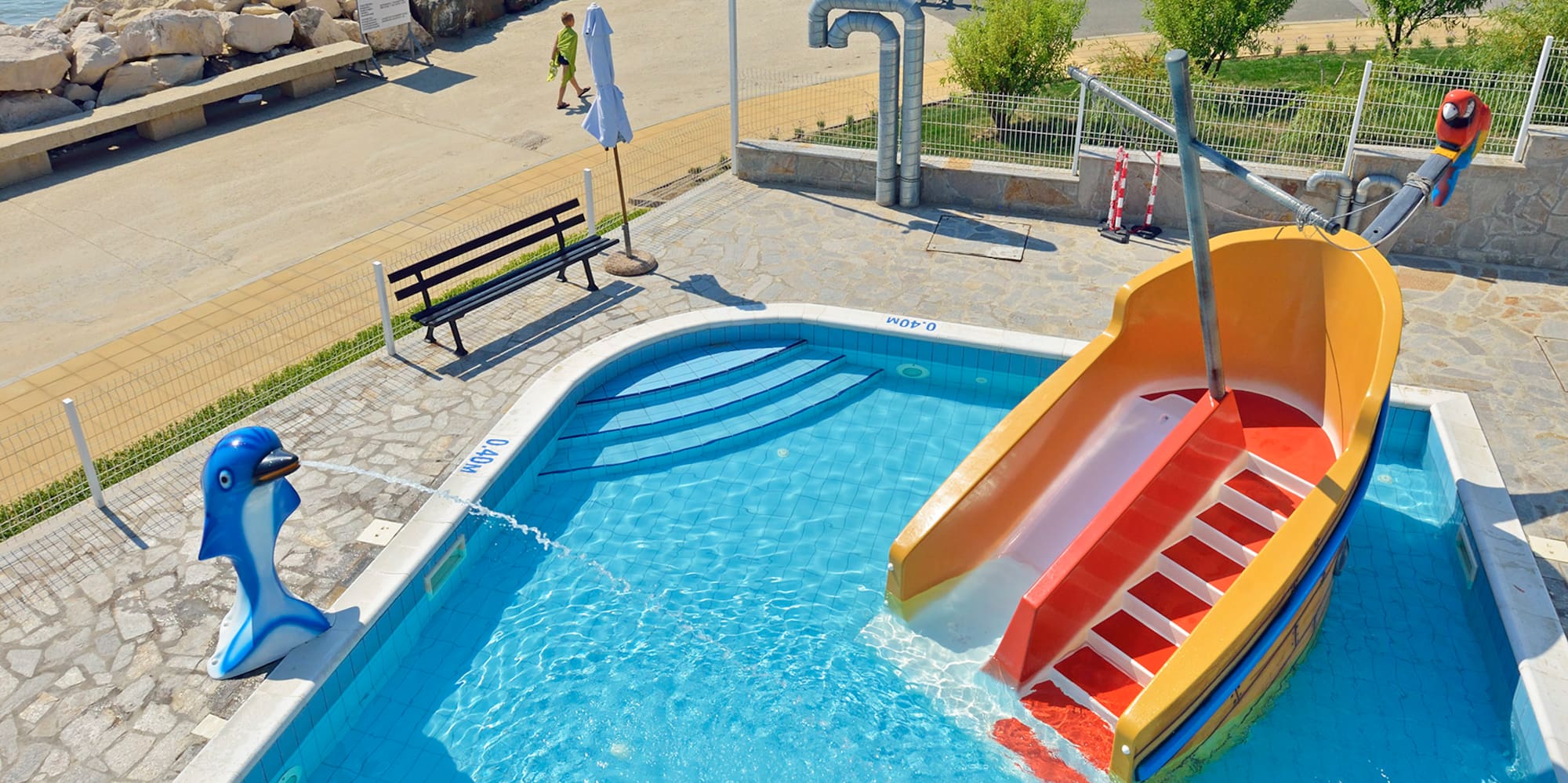 a pool with a slide and a boat