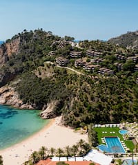 a beach with a body of water and a resort