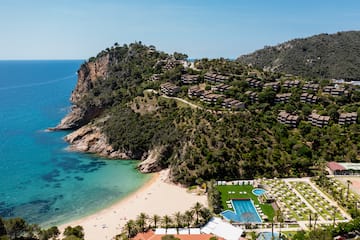 a beach with a body of water and a resort