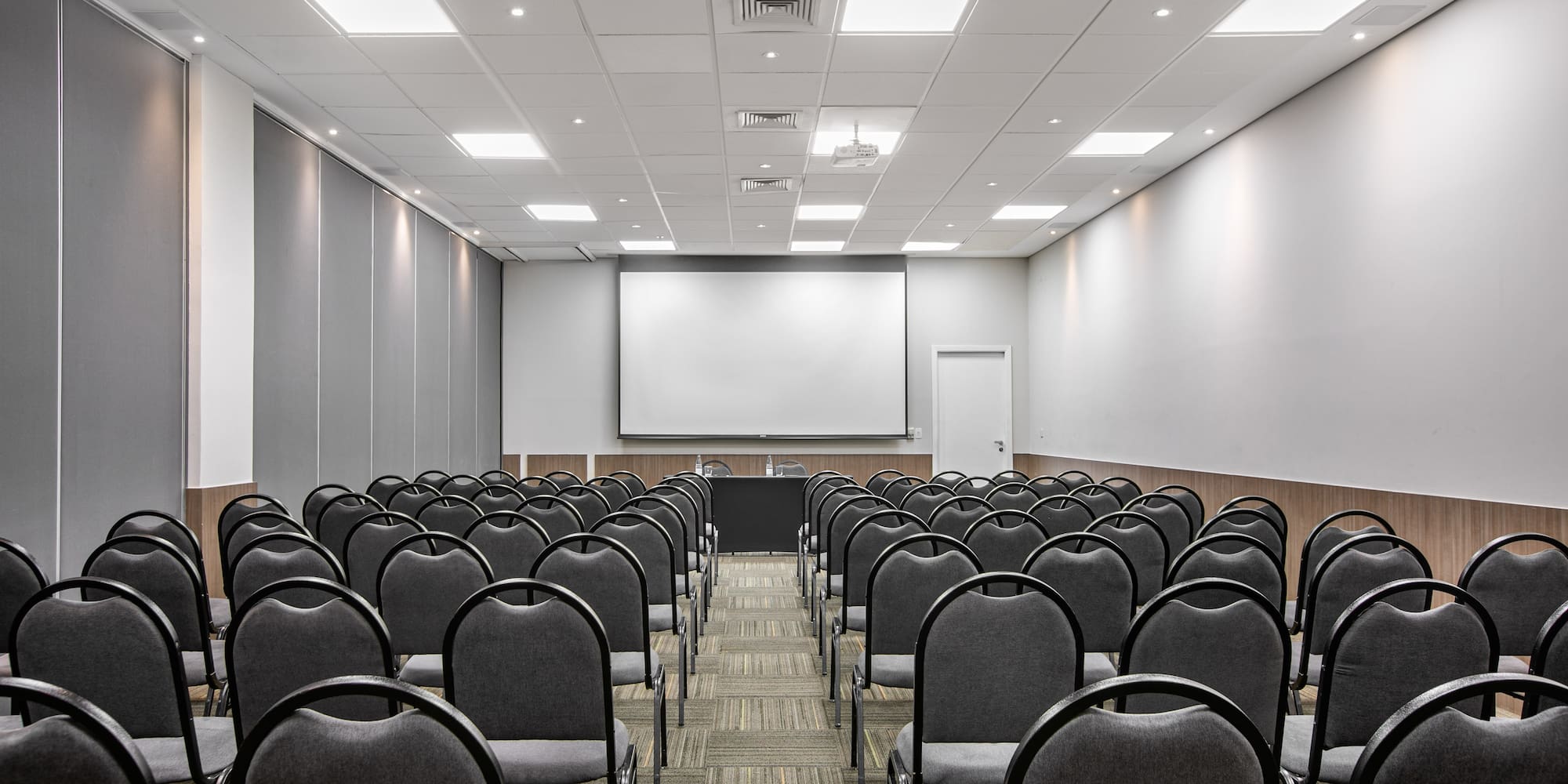 a room with chairs and a projector screen