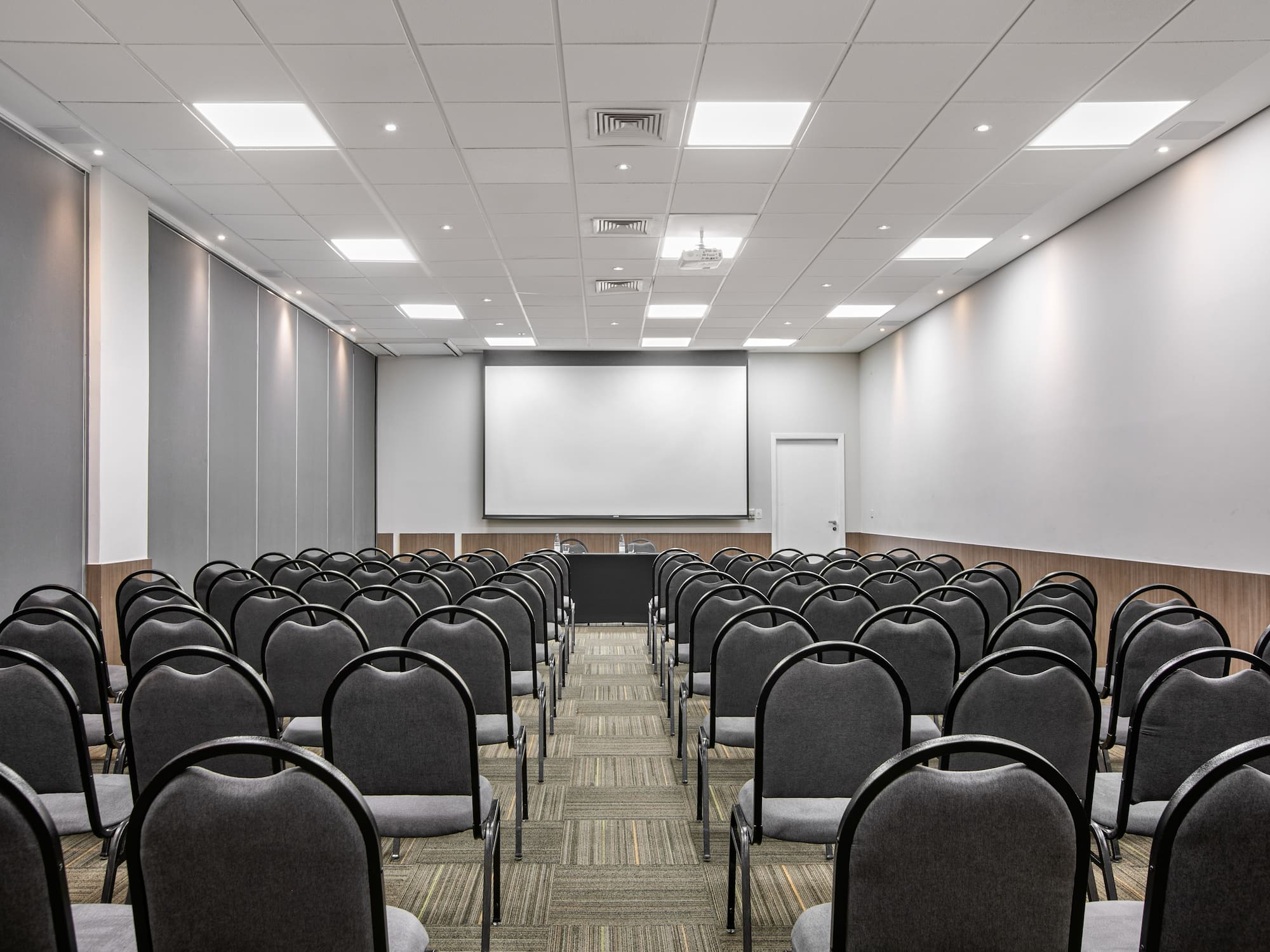 a room with chairs and a projector screen