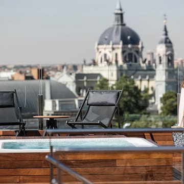 a woman standing on a deck with a hot tub and a city in the background