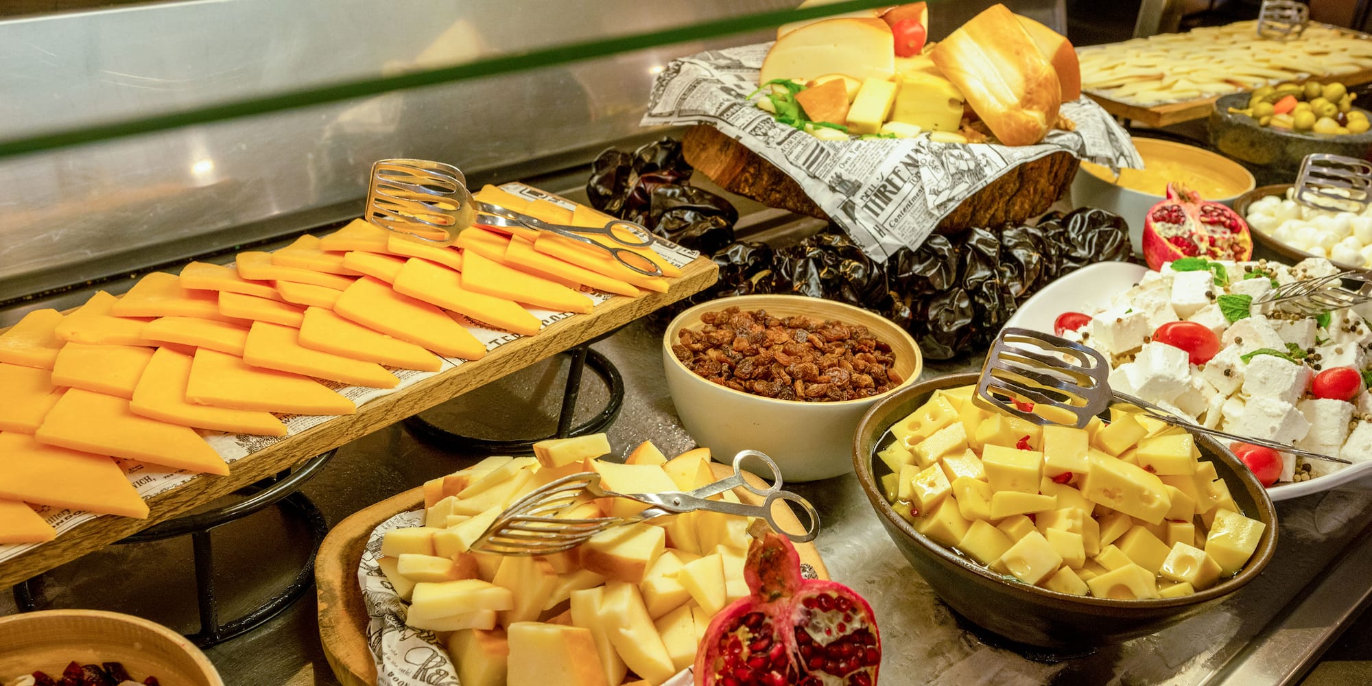 a variety of cheeses and other food on a counter