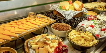 a variety of cheeses and other food on a counter