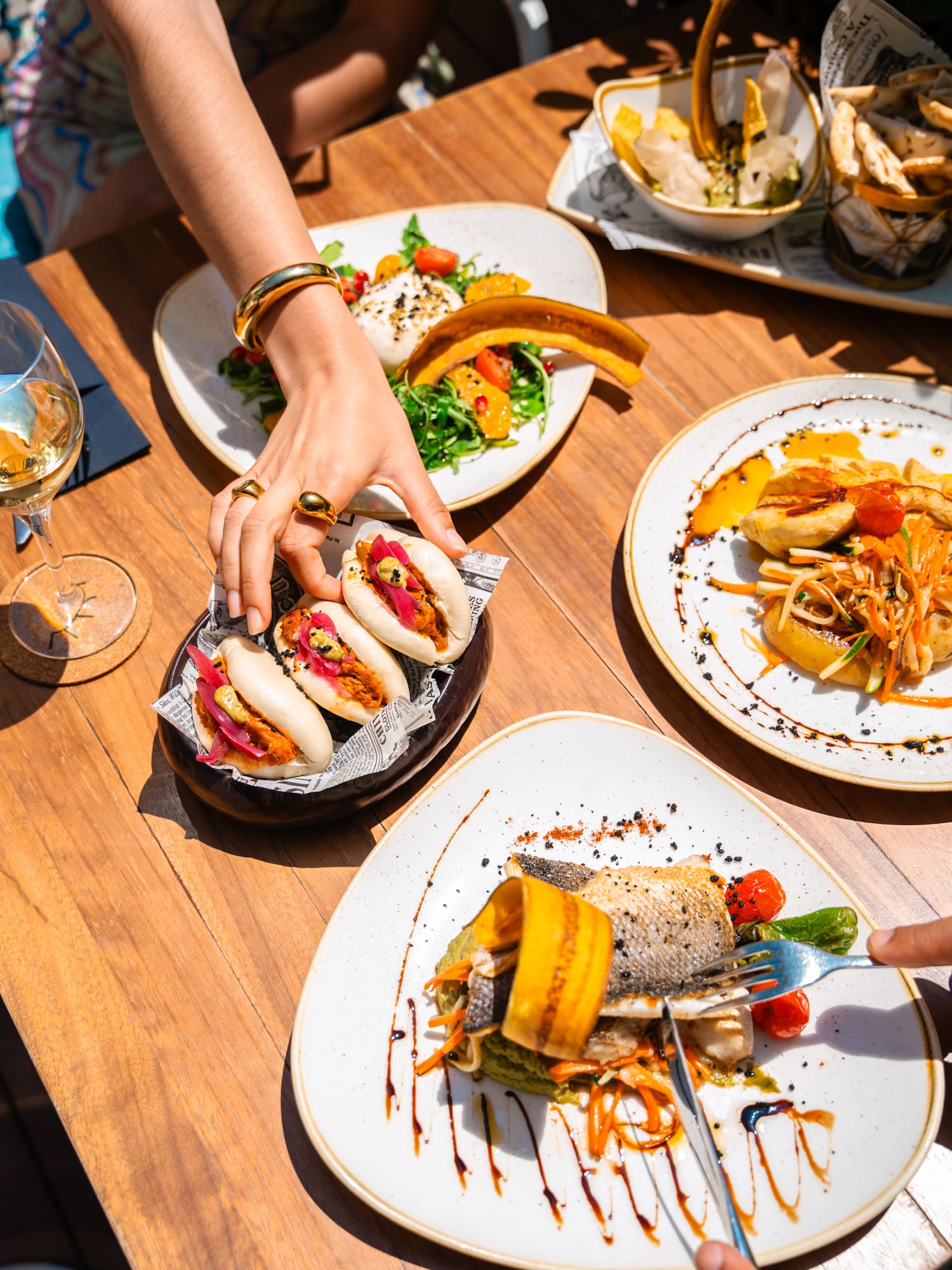 a person's hand reaching for food on plates