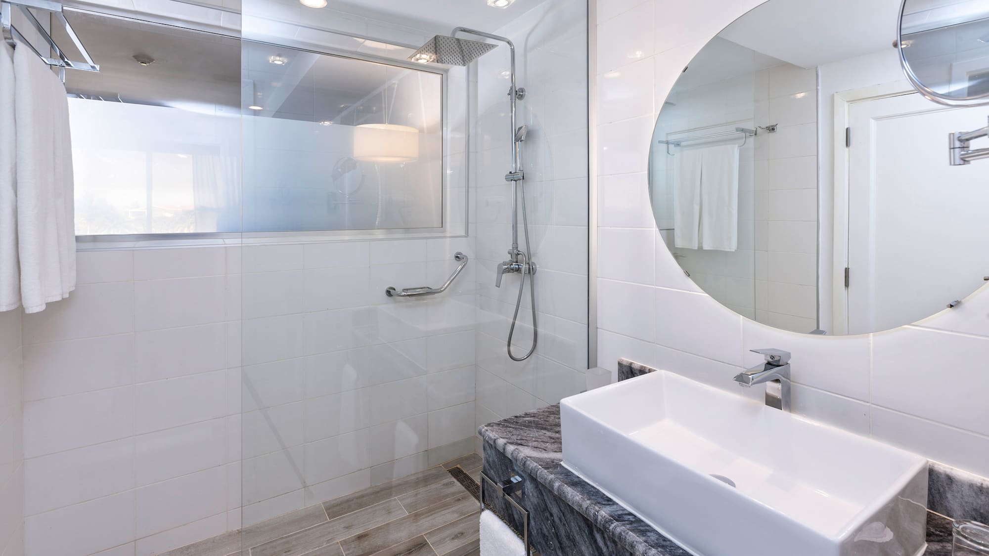 a bathroom with a round mirror and a sink
