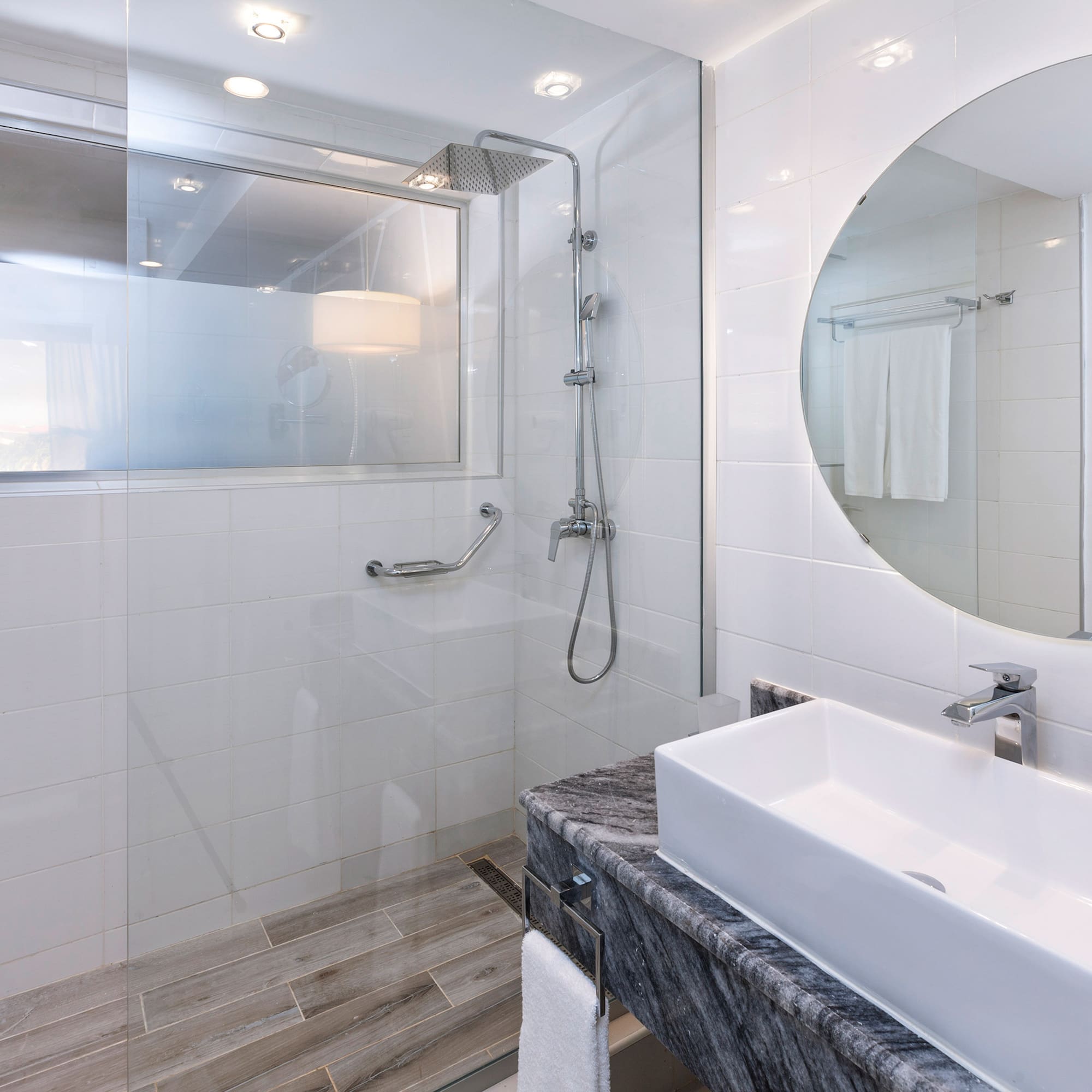 a bathroom with a round mirror and a sink