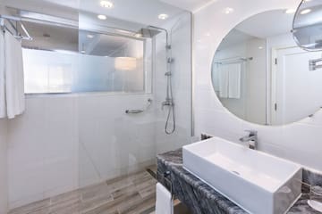 a bathroom with a round mirror and a sink