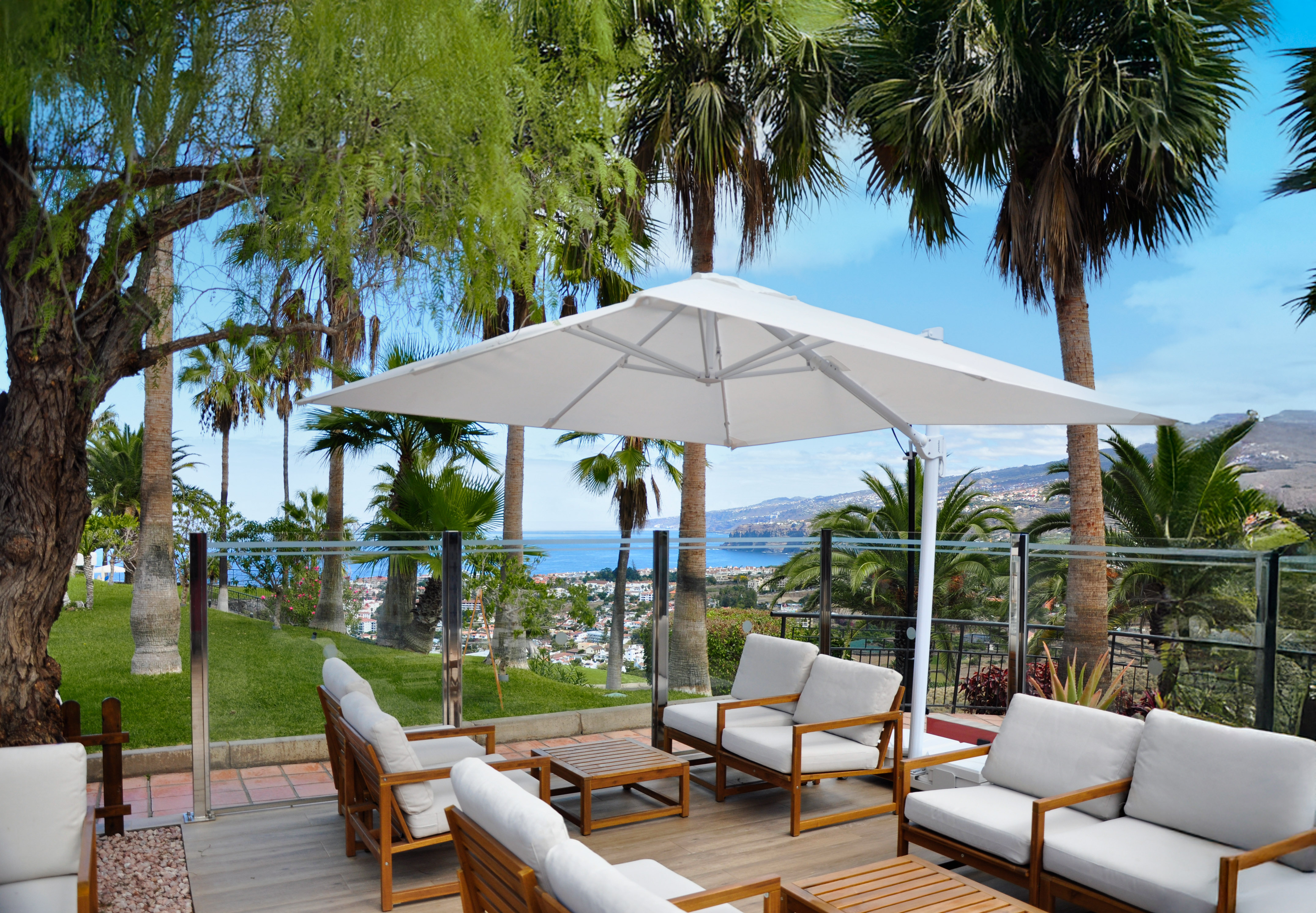 a patio with white chairs and umbrella