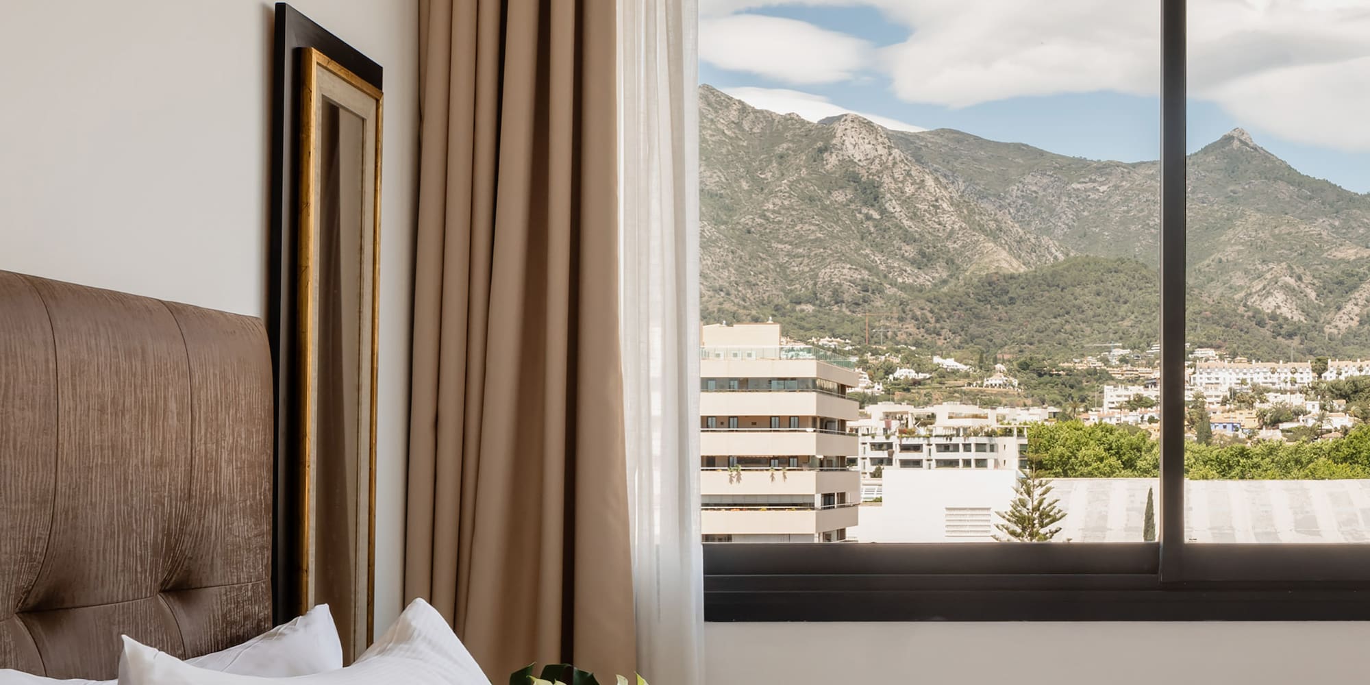a bed with a window and a view of mountains