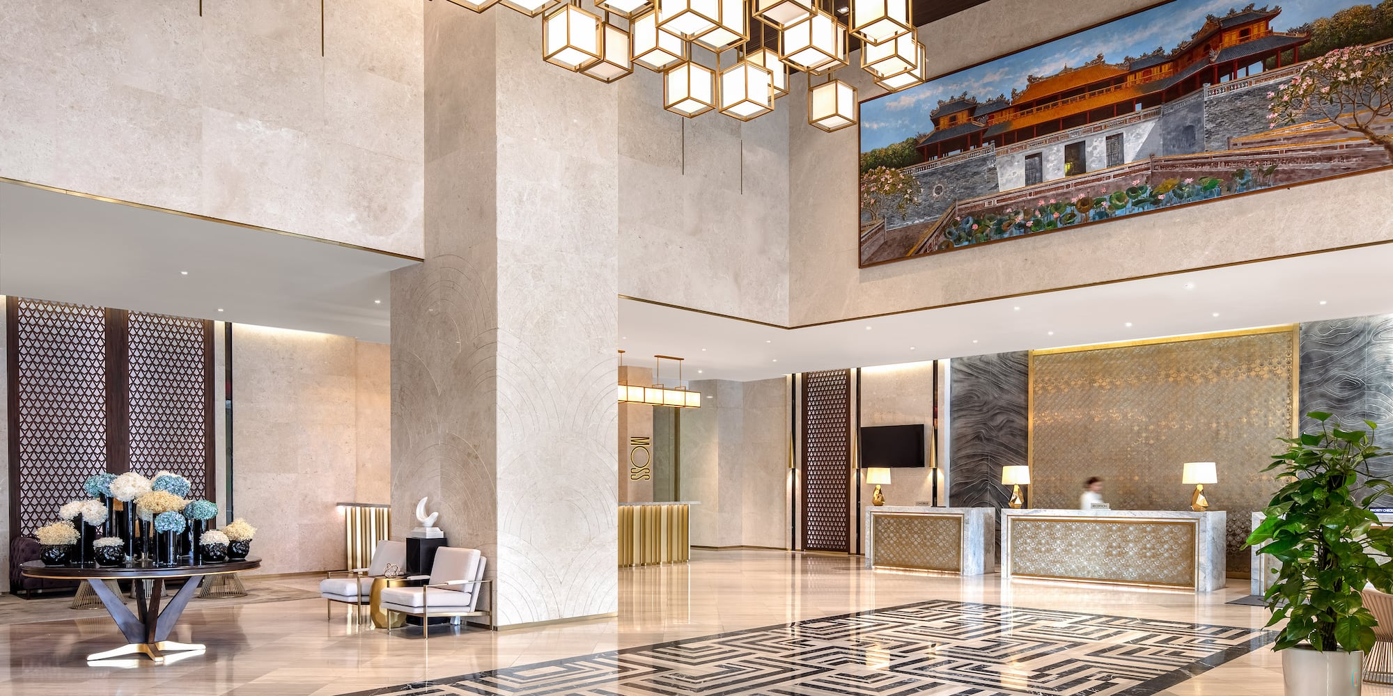 a lobby with a large chandelier and a large picture from the ceiling