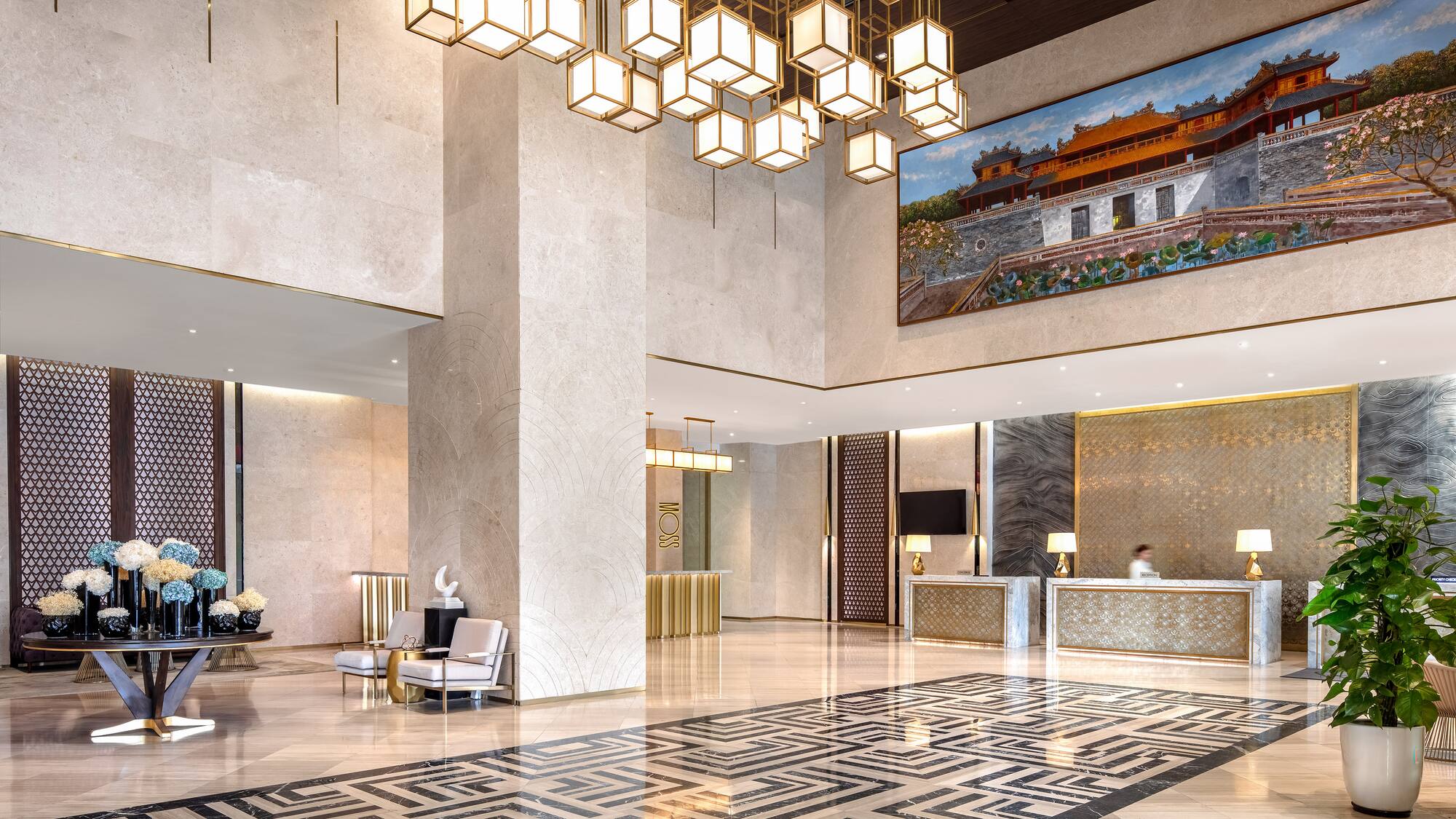 a lobby with a large chandelier and a large picture from the ceiling