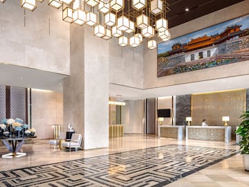 a lobby with a large chandelier and a large picture from the ceiling